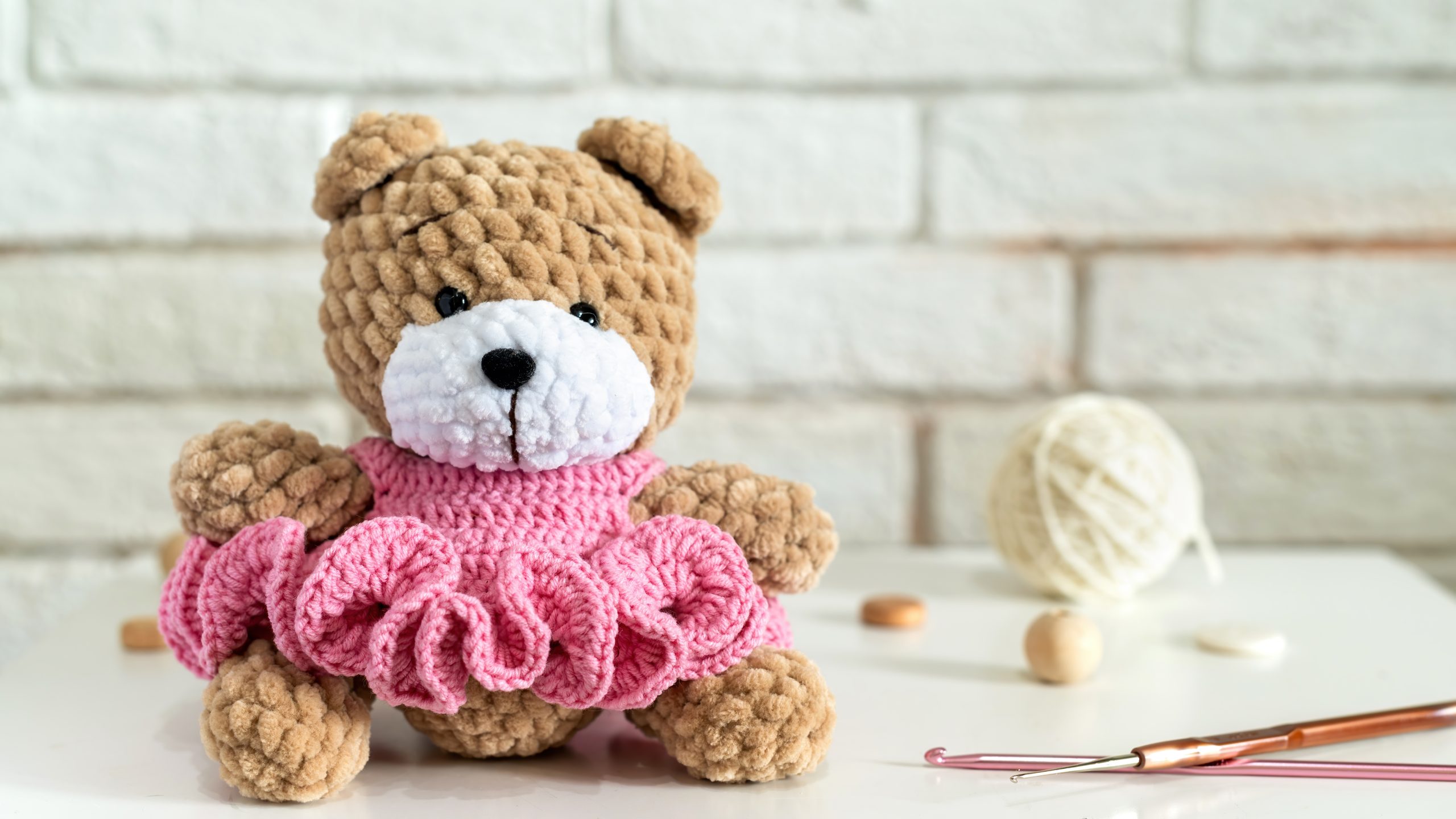 mainan boneka organik - Knitted teddy bear on the table